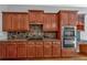 Well-equipped kitchen featuring wood cabinets, granite countertops, stainless steel appliances and tile backsplash at 5407 Waters Edge Trl, Roswell, GA 30075