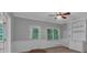 Bright room features neutral walls, ceiling fan, carpeted floor, built-in shelves, and large windows at 5407 Waters Edge Trl, Roswell, GA 30075