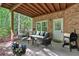 Undercover patio with brick walls, outdoor seating, grill, and view of the backyard at 5407 Waters Edge Trl, Roswell, GA 30075