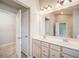 Bathroom with double vanity, large mirror with cosmetic lighting, and access to walk-in closet at 1216 Foxcroft Ln, Cumming, GA 30041