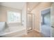 Well lit bathroom featuring a soaking tub, tiled floor and walk-in shower with glass door at 1216 Foxcroft Ln, Cumming, GA 30041