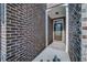 Inviting covered entryway with brick siding and a solid front door at 1216 Foxcroft Ln, Cumming, GA 30041