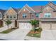 Beautiful townhome exteriors with brick facades, garages, and landscaped front yards at 1216 Foxcroft Ln, Cumming, GA 30041