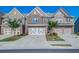 Well-kept townhomes with manicured lawns and driveways on a sunny day at 1216 Foxcroft Ln, Cumming, GA 30041