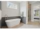 A modern bathroom featuring a freestanding tub, tiled floors and a glass-enclosed shower at 1811 Kent Ave, Dunwoody, GA 30338