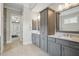 Bathroom featuring double sink, large mirror and a gray cabinet; view of the Primary bedroom can be seen at 1811 Kent Ave, Dunwoody, GA 30338
