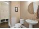 Bathroom with sink, toilet, and a mirror with a round frame at 1811 Kent Ave, Dunwoody, GA 30338