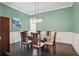 Elegant dining room with hardwood floors, stylish lighting, wainscoting and seating for six at 1811 Kent Ave, Dunwoody, GA 30338