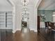 Spacious hallway featuring hardwood floors, built-in shelving, and views into the dining and living areas at 1811 Kent Ave, Dunwoody, GA 30338