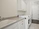 Functional laundry room with built-in cabinets, a sink, and modern washer and dryer at 1811 Kent Ave, Dunwoody, GA 30338