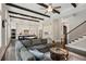 Open-concept living area with hardwood floors, exposed beams, stylish furnishings, and adjacent kitchen at 1811 Kent Ave, Dunwoody, GA 30338