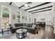 Spacious living room with dark wood beams, large windows, and a comfortable sectional sofa at 1811 Kent Ave, Dunwoody, GA 30338