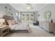 A well-lit main bedroom with a plush bed, decorative mirrors and a tranquil view to the outdoor area at 1811 Kent Ave, Dunwoody, GA 30338