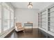Cozy office featuring custom built-ins, shuttered windows, hardwood floors, and a comfortable chair at 1811 Kent Ave, Dunwoody, GA 30338