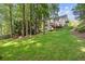 Expansive backyard featuring a lush lawn, mature trees, and a deck perfect for outdoor enjoyment at 1880 Barrett Dr, Cumming, GA 30040
