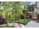 Stone steps lead to a tiered backyard with a deck and mature trees at 1880 Barrett Dr, Cumming, GA 30040
