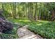 Stone steps leading to a lush backyard with mature trees and plenty of space for outdoor activities at 1880 Barrett Dr, Cumming, GA 30040