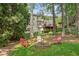 Charming backyard with a fire pit and Adirondack chairs surrounded by mature trees at 1880 Barrett Dr, Cumming, GA 30040