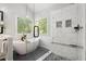 Bright bathroom featuring a glass shower, soaking tub, and neutral finishes at 1880 Barrett Dr, Cumming, GA 30040
