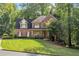 Charming brick home with well-manicured lawn and mature trees providing ample shade at 1880 Barrett Dr, Cumming, GA 30040