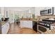 Well-lit kitchen featuring granite countertops, white cabinetry, and stainless steel appliances at 1880 Barrett Dr, Cumming, GA 30040