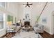 Bright living room with large windows, a cozy fireplace, and hardwood floors at 1880 Barrett Dr, Cumming, GA 30040