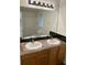 Bathroom featuring double sink vanity with dark tile backsplash and ample lighting at 214 Sweetwater Cir, Powder Springs, GA 30127