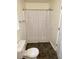 Bathroom featuring tub-shower combo with checked curtain and matching tile floors at 214 Sweetwater Cir, Powder Springs, GA 30127