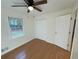 Well-lit bedroom showcasing hardwood floors, a double door closet, and a view from the window at 214 Sweetwater Cir, Powder Springs, GA 30127