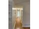 Hallway with wood floors leading to several rooms with white painted walls and a wall of built-in shelves at 214 Sweetwater Cir, Powder Springs, GA 30127