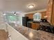 Bright kitchen boasts oak cabinets, modern black appliances, and an open breakfast bar with backyard views at 214 Sweetwater Cir, Powder Springs, GA 30127