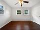 A bedroom featuring dark hardwood floors, two windows, and a ceiling fan at 3653 Mecklinburg Pl, Decatur, GA 30032