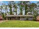 Charming gray home featuring a carport, wood accents, and a spacious front yard at 3653 Mecklinburg Pl, Decatur, GA 30032