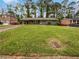 Landscaped front yard of cozy home with gray exterior, carport, and mature shade trees at 3653 Mecklinburg Pl, Decatur, GA 30032