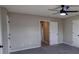 Bedroom with gray carpet, a ceiling fan, and two doors visible in the background at 1700 Conductor Ln, Conyers, GA 30013