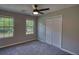 Bedroom with gray carpet, a ceiling fan, two windows, and a large closet at 1700 Conductor Ln, Conyers, GA 30013