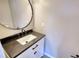 Modern powder room featuring a sleek vanity with dark countertop and decorative mirror at 1700 Conductor Ln, Conyers, GA 30013