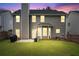 Exterior backyard view at twilight, the patio is well-lit, showcasing its potential for nighttime enjoyment and relaxation at 449 Highlands Loop, Woodstock, GA 30188