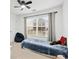Comfortable bedroom with a large window, neutral carpeting, and a ceiling fan at 449 Highlands Loop, Woodstock, GA 30188