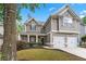Inviting two-story home features a two-car garage, landscaped front yard, and charming covered porch at 449 Highlands Loop, Woodstock, GA 30188