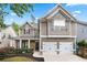 Charming two-story home with a two-car garage, landscaped front yard, and inviting covered porch at 449 Highlands Loop, Woodstock, GA 30188