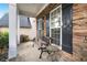 Relaxing front porch area with stone accents, features seating for enjoying the outdoors at 449 Highlands Loop, Woodstock, GA 30188