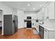 Well-lit kitchen features white cabinets, stainless steel appliances, and hardwood floors at 449 Highlands Loop, Woodstock, GA 30188