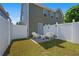 Virtually staged fenced backyard with a concrete patio and outdoor seating at 577 Cypher Dr, Suwanee, GA 30024