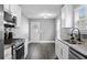 Well-lit kitchen features stainless steel appliances, granite countertops, and sleek tile backsplash at 577 Cypher Dr, Suwanee, GA 30024