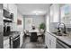Well-lit kitchen features stainless steel appliances, granite countertops, and sleek tile backsplash at 577 Cypher Dr, Suwanee, GA 30024