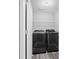 Bright laundry room featuring a full size washer, dryer, and wire shelving at 577 Cypher Dr, Suwanee, GA 30024