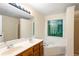 Bathroom featuring a large jetted tub, double sinks, and a large vanity mirror at 6939 Waters Edge Dr, Stone Mountain, GA 30087