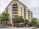 Exterior view of condominium building with multiple balconies and beautiful mature trees at 711 Cosmopolitan Ne Dr # 123, Atlanta, GA 30324
