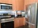 Updated kitchen featuring stainless steel appliances, wood cabinets, and sleek black countertops at 711 Cosmopolitan Ne Dr # 123, Atlanta, GA 30324